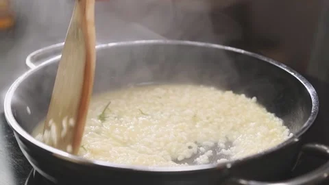 The cook stirring risotto in the frying pan, slow motion. Stock Footage 154370547
