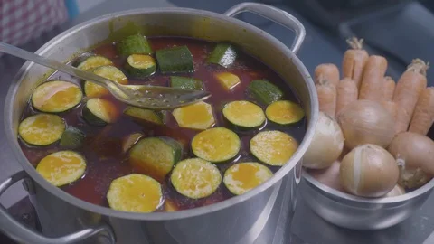 A cook is stirring vegetables on a large pot Stock Footage