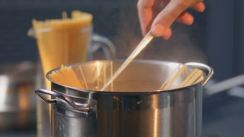 Cook stirs boiling pasta preparing Italian traditional food Spaghetti Stock Footage 129613879
