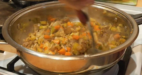 Cook stirs a vegetable stew. Ragout is cooked in large metal pan Video stock 318418841