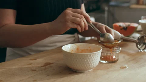 Cook straining papaya puree on a cutting board for an octopus carpaccio dish in Stock Footage 199457559