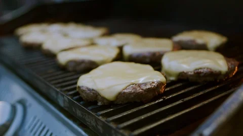 Cook takes burger with melted cheese from the grill. Stock Footage 97794065