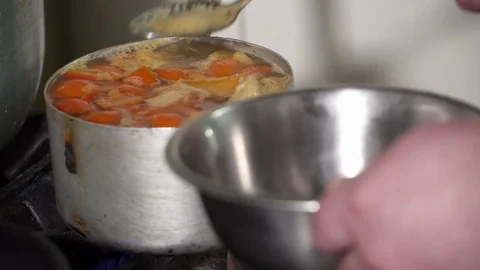 Cook taking off the scum from the boiling soup Stock Footage 73475543