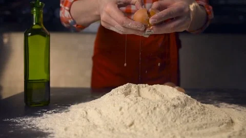Cook throw an egg on a pile of flour .In the kitchen of a pizzeria 動画素材 74357241
