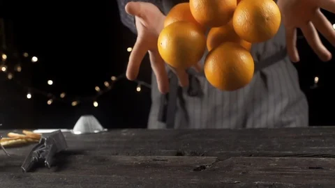 Cook throws oranges on a wooden table, cooking in slow motion Video stock 105367115