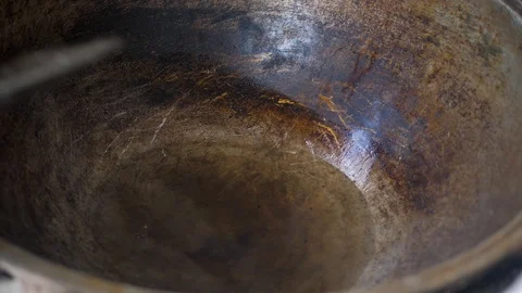The cook throws pieces of meat (liver) into a hot iron pot Stock Footage 125696085