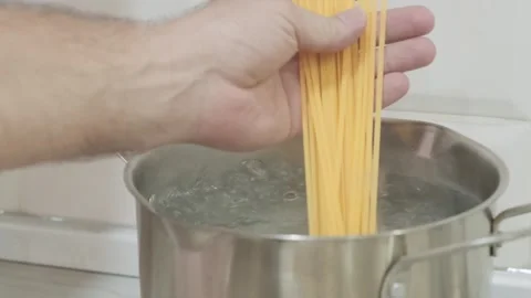 Cook throws raw spaghetti into boiling water Stock-Footage 279025507