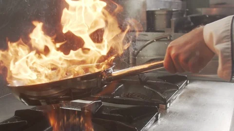 Cook throws shrimp in pan with fire. Slow motion video Stock Footage 124687285