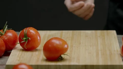 The cook throws some tomatoes onto the chopping board. Stock Footage 272471161