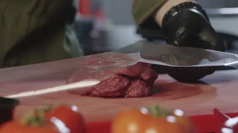 The cook throws the veal meat on the board and begins to beat it. Stock Footage 231208690