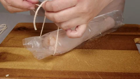 Cook ties the ends of baking sleeve Video stock 165431556