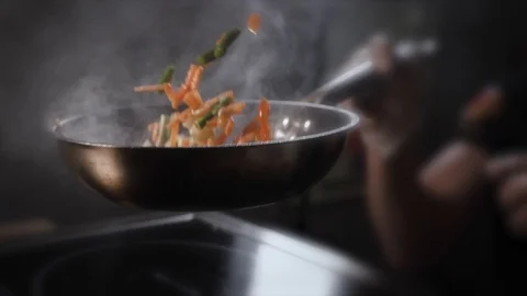 The cook tosses a wok in the pan Stock Footage 124274869