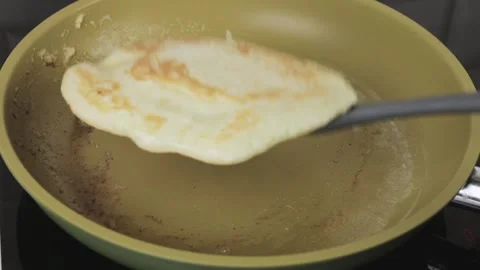The cook turns the pancake on the pan Stock Footage 147171845