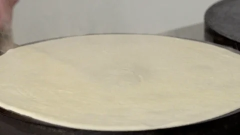 Cook turns a pancake on a professional surface in slow motion Stock Footage 94124175