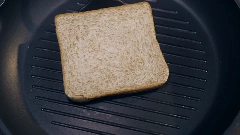 The cook turns toast from side to side on the hot grilling pan, making the Stock Footage 112352484