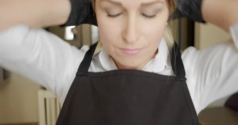 Cook tying a kitchen apron in the kitchen. Close-up V2 Stock Footage 140412390