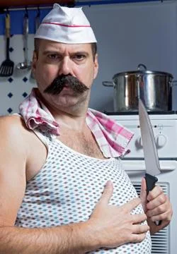 Cook in undershirt standing in the kitchen Stock Photos