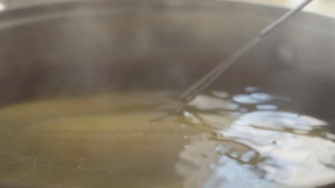 The cook uses a fork to check the readiness of the corn boiling in the pot 库存影片 337118336