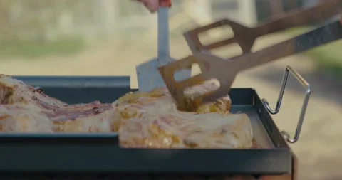 Cook using tongs, turns over large piece of meat, grill, picnic after quarantine Stock Footage 131094267