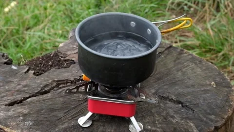 Cook water using a portable gas stove Video stock 291530381