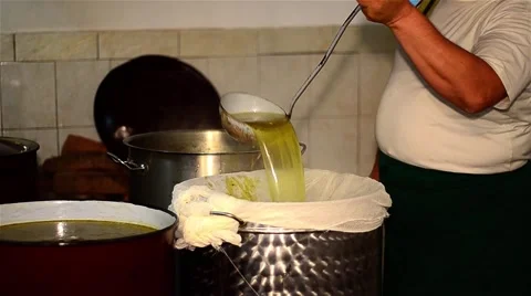 Cook which strain the soup through a cheesecloth into a large pot on the stove Vídeos de archivo 63432250