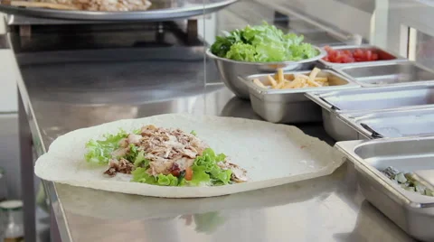 Cook wraps meat and vegetables in a pita bread for cooking shawarma. Stock Footage 50179642