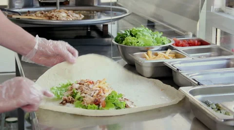 Cook wraps meat and vegetables in a pita bread for cooking shawarma. Stock Footage 50179746