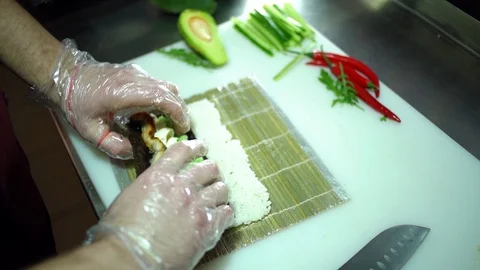 Cook wraps the sushi roll. Video stock 106389060
