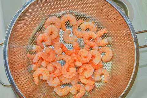 Cooked and peeled prawns in strainer. Food photography. Healthy food Stock-Fotos