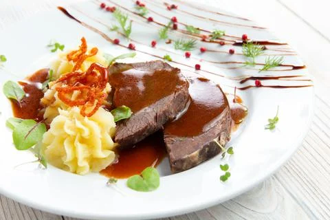 Cooked beef and mashed potatoes. In a plate. On a light background. Stock Photos