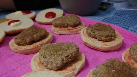 Cooked Beef Burger Patties Placed on Sauced Buns for Meal Preparation Stock Footage 341998592