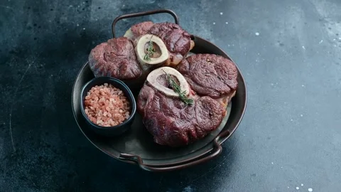 Cooked beef shanks served with seasoning on a rustic platter in a modern kitchen Stock Footage 305229407