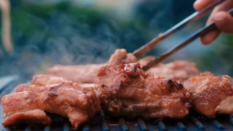Cooked beef steak or pork ribs, toasting meat on a metal electric grill Stock Footage 119685192