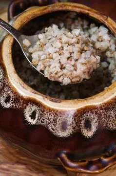 Cooked buckwheat in a clay pot. Stock Photos