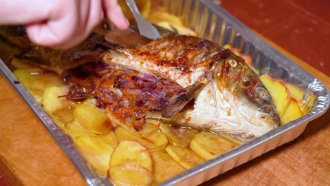 Cooked carp fish with potatoes on a plate, cut with a knife Stock Footage 248530256