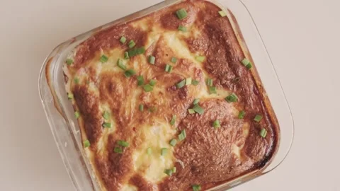 Cooked casserole with golden crust in glass bowl on table 스톡 동영상 264092653