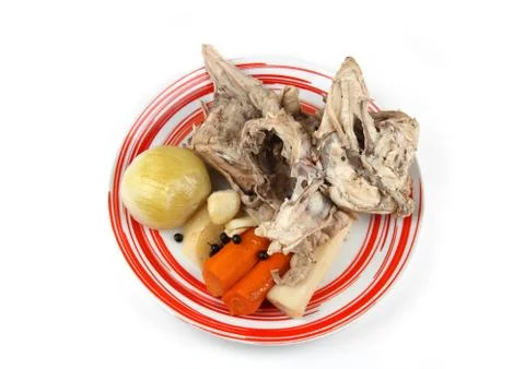 Cooked chicken bones and vegetables from chicken soup on plate. Stock Photos