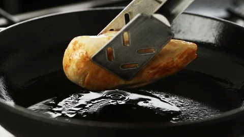 Cooked chicken fillet turned in a hot cast iron pan Stock Footage 92149095