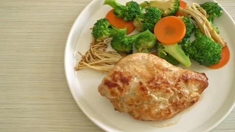 Cooked chicken with mixed vegetables on a white plate Stock Photos