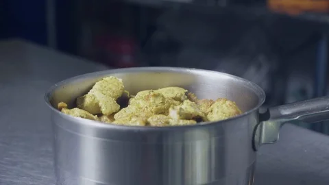 Cooked chicken over the tabletop, cook brings sausages to complement the dish Stock Footage 129993426
