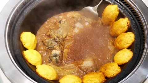 A cooked Chinese stew of fish and noodles in a cast iron Stock Footage 335088324
