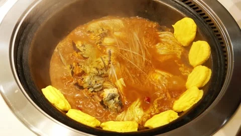 A cooked Chinese stew of fish and noodles in a cast iron Stock Footage 335088356