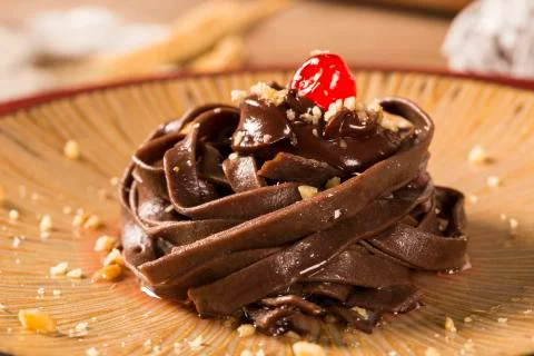 Cooked chocolate pasta spaghetti with raspberry sauce Stock Photos