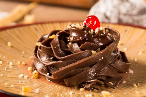 Cooked chocolate pasta spaghetti with raspberry sauce Stock Photos