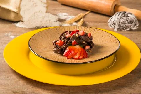 Cooked chocolate pasta spaghetti with raspberry sauce Foto stock