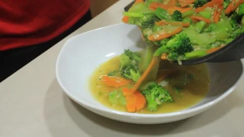 Cooked cooked vegetables. Pour vegetable dishes on plates Stock Footage 334268245