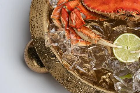 Cooked crab on ice with lime in gold serving tray. Close up angle showing r.. Stock Photos