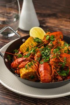 Cooked crayfish with corn and herbs in a serving pan Stock Photos