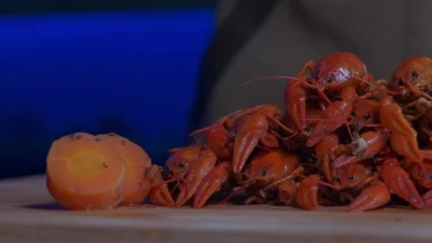 Cooked crayfishs are stacked in a pyramid on the table by a cook with onions and Stock Footage 181530854