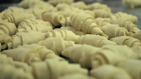 Cooked croissants are piled on a tray. Croissants before baking Stock Footage 274345474